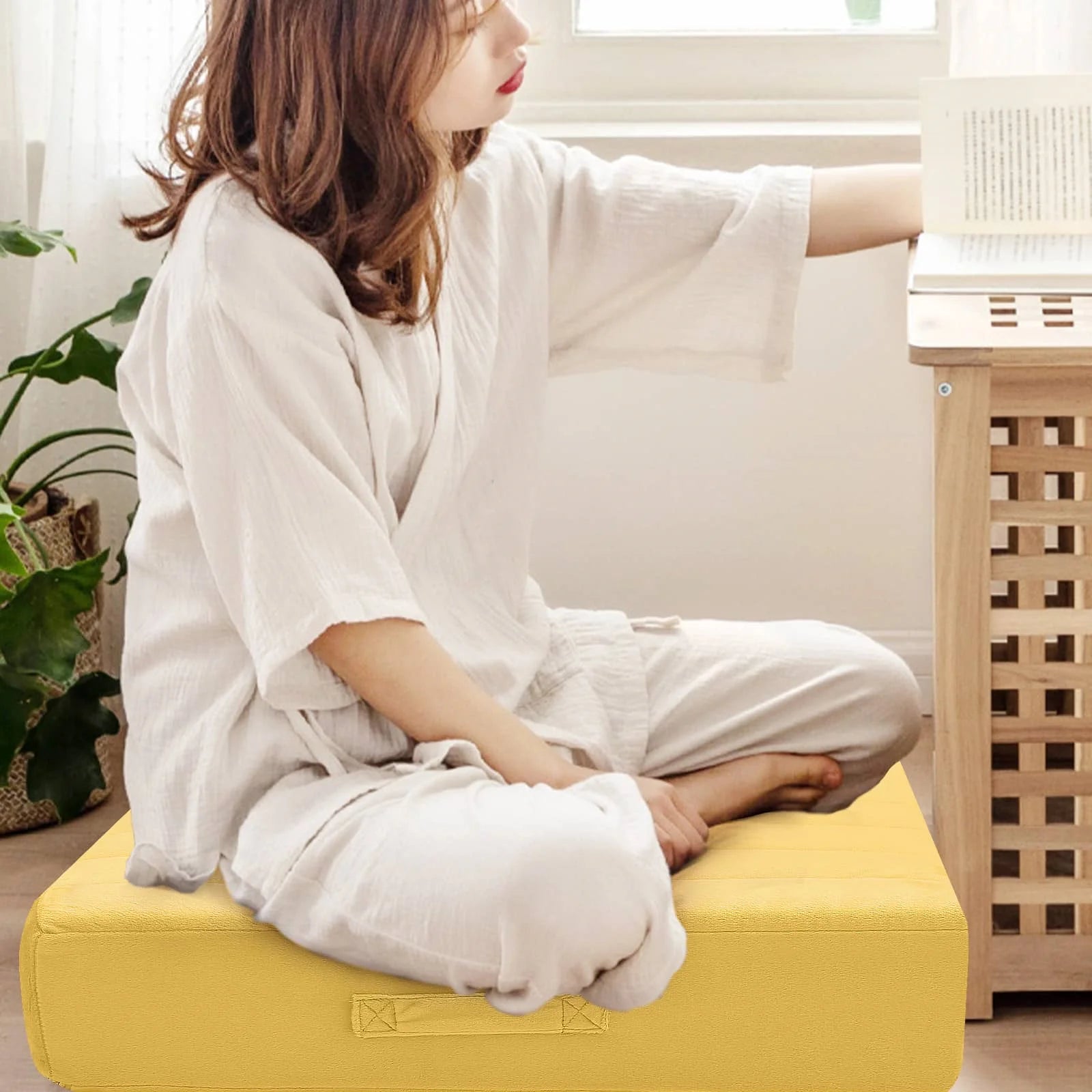 Woman sitting on Glowosfa Large Floor Pillows reads