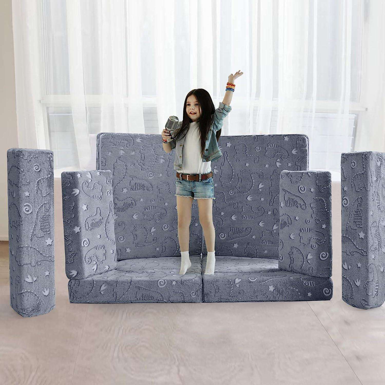 Girls singing on a small stage built by Glowing dinosaur kids paly couch
