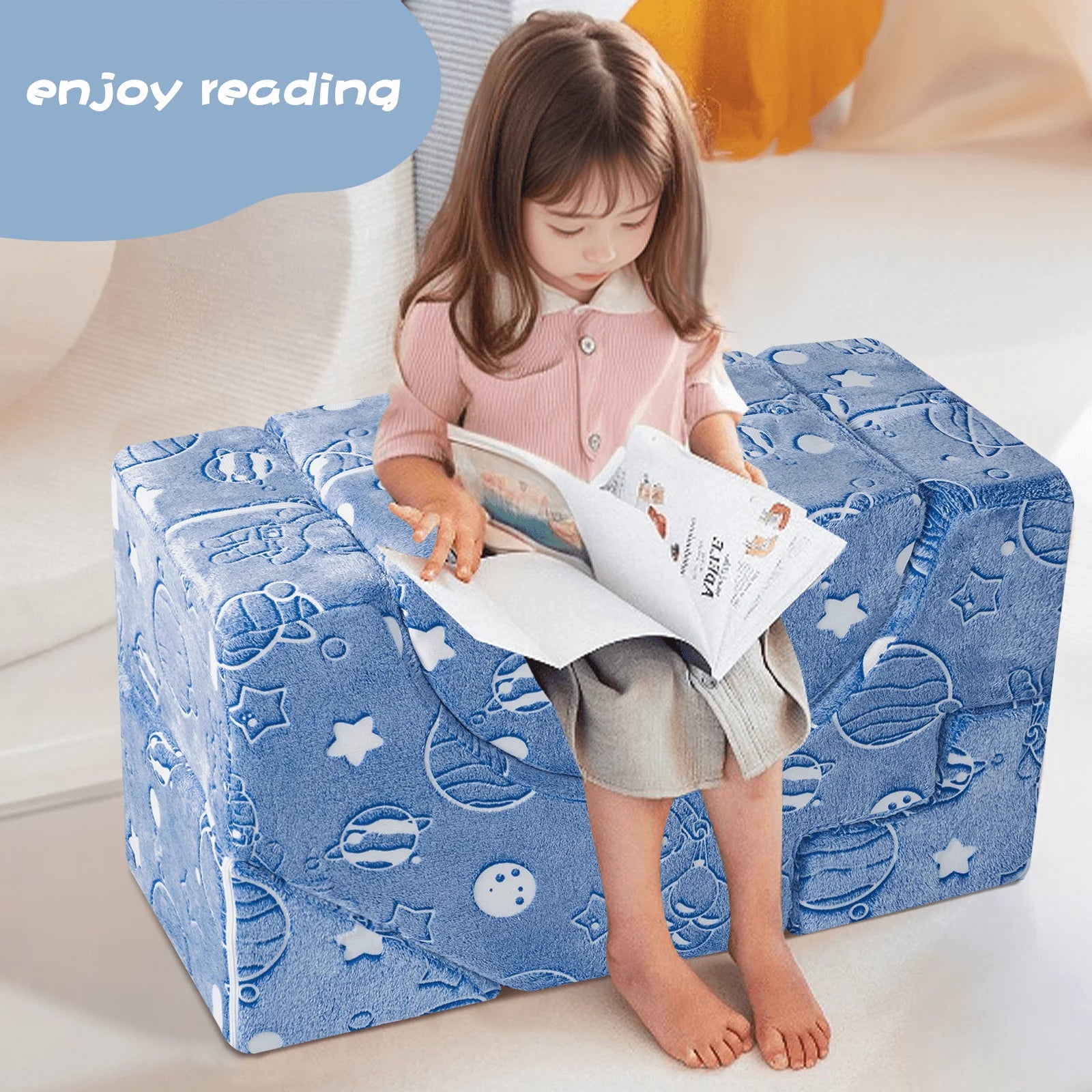 Girl reading a book while sitting on a U-shaped kids chair made up of Glowsofa's Space Astronaut Climbing Kids Play Couch