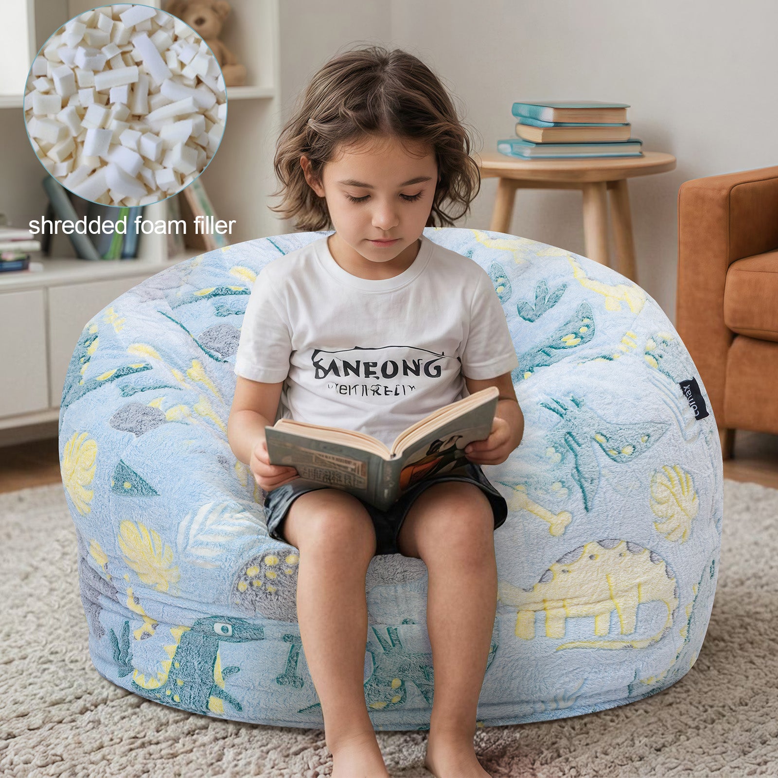 Boy reads a book while sitting on Comax's Blue Dinosaurs Bean Bag Chair for kids, padded with shredded foam.